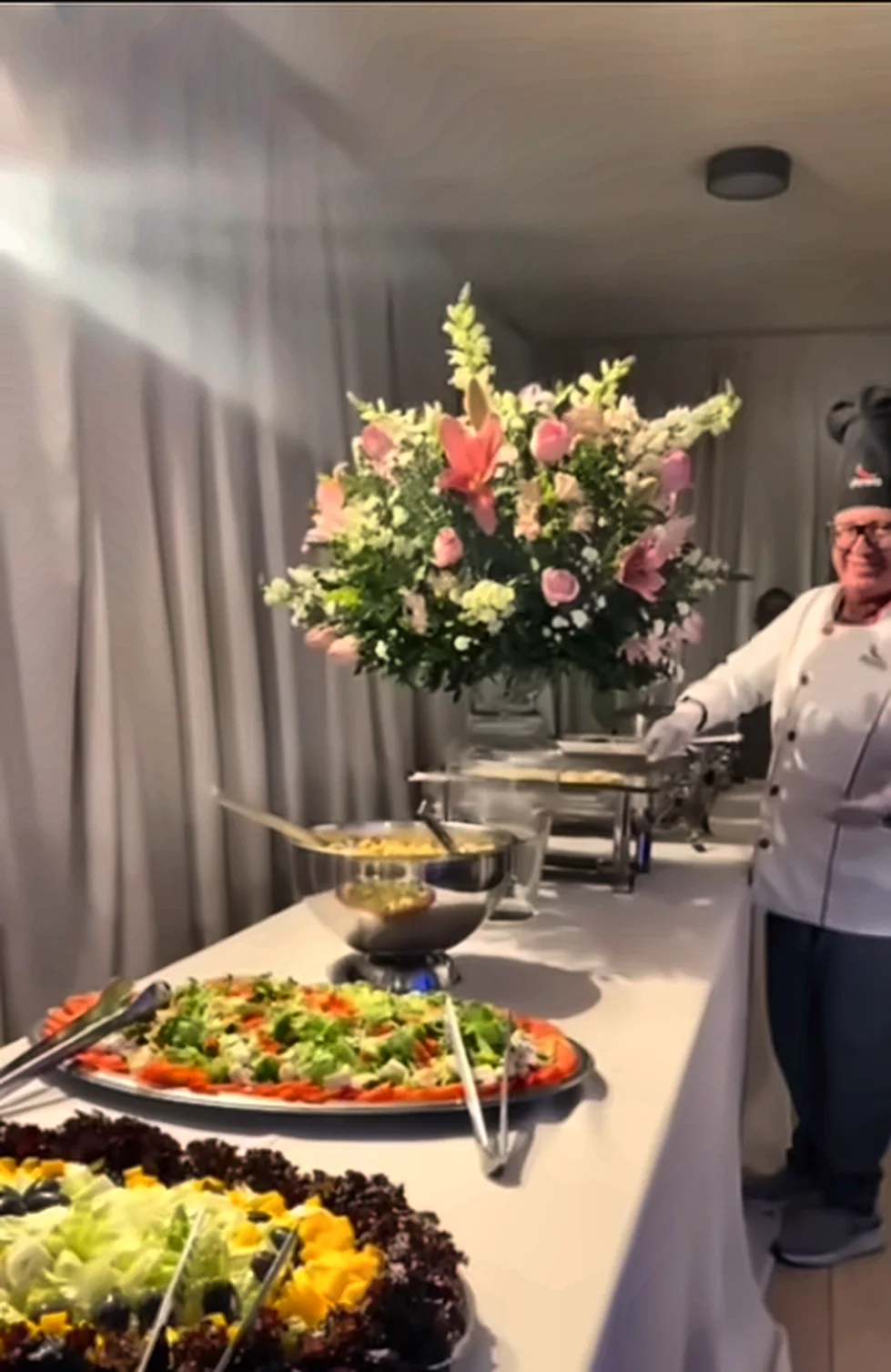 Buffet de casamento com arranjo de flores e saladas
