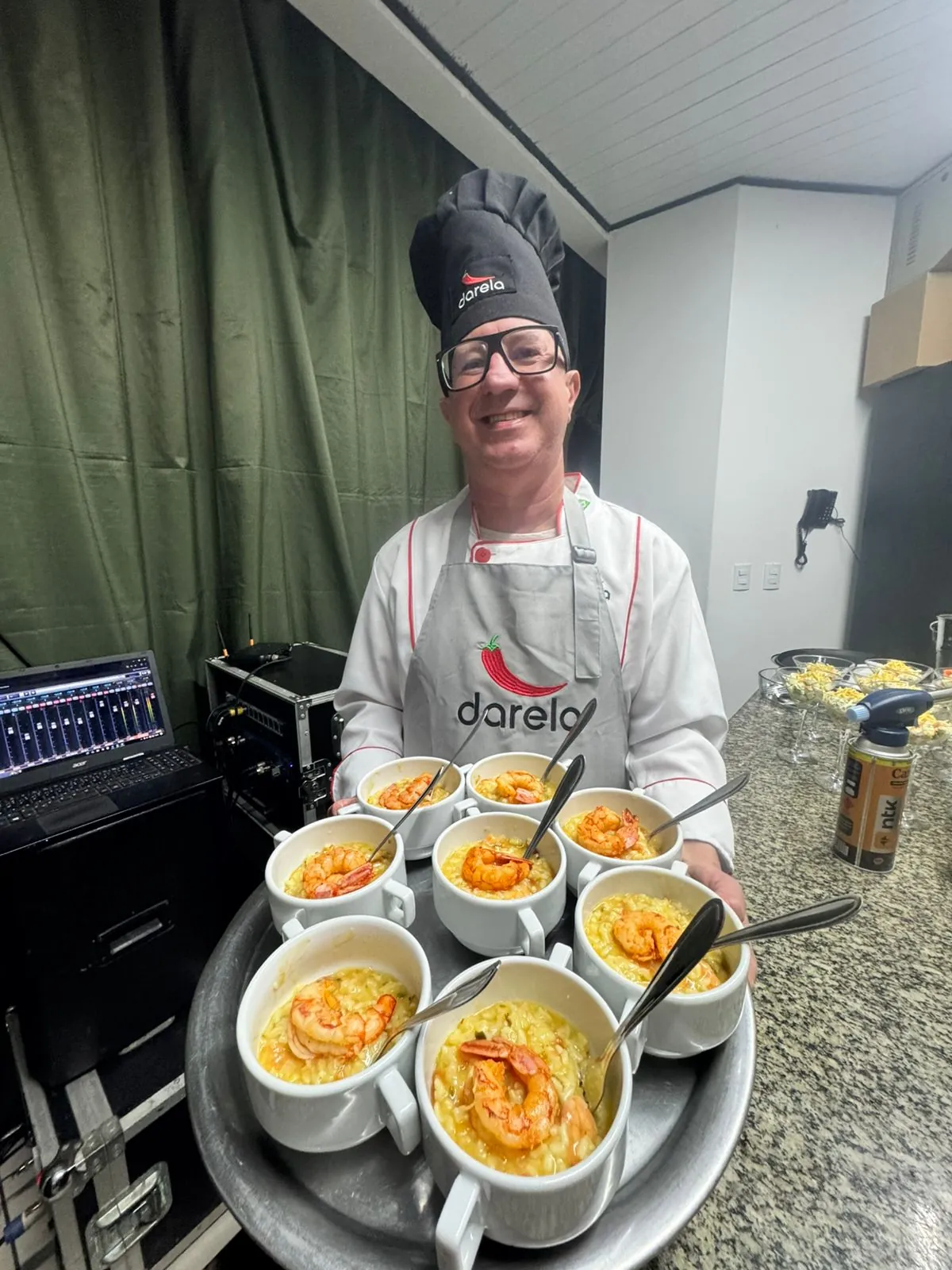 Chef Dilson Darela segurando bandeja com cumbucas de risoto de camarão