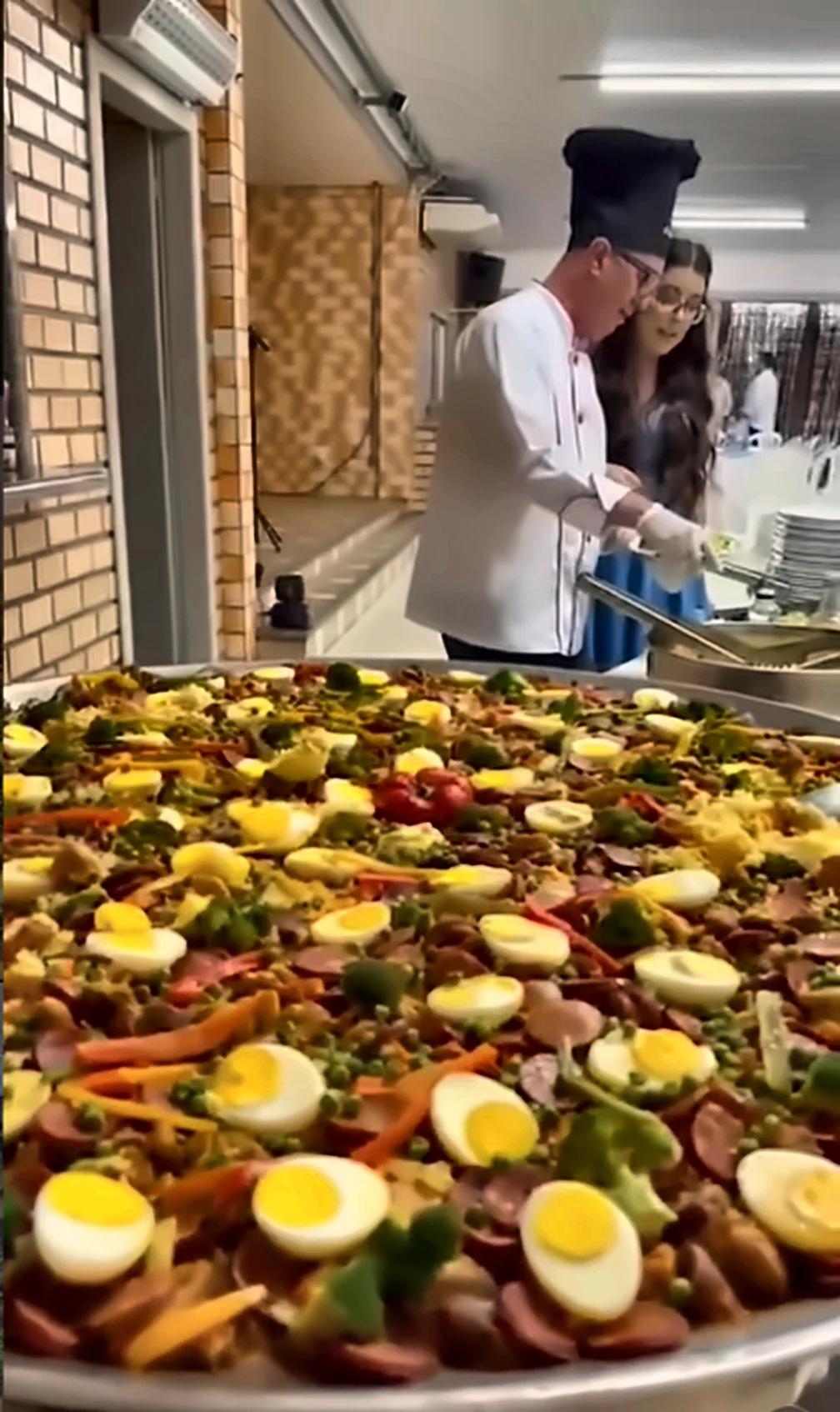Paellera com paella caipira, linguiça, legumes e ovos cozidos