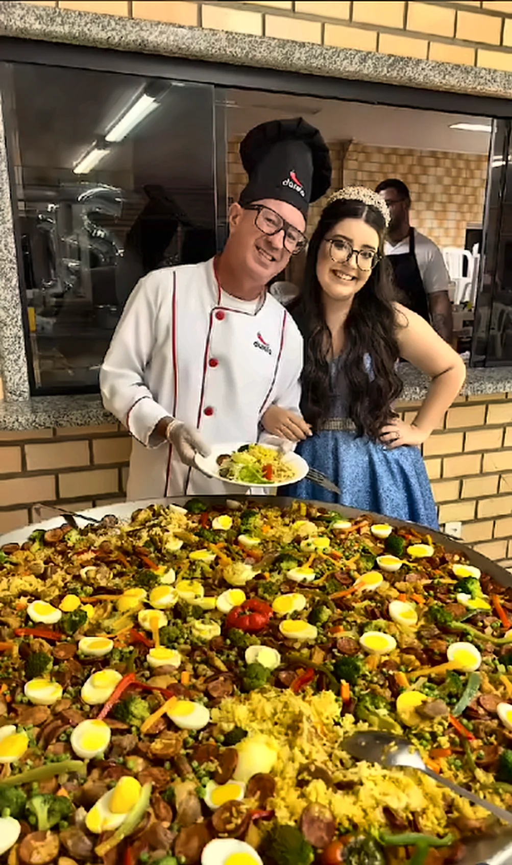 Chef e debutante ao lado da paellera